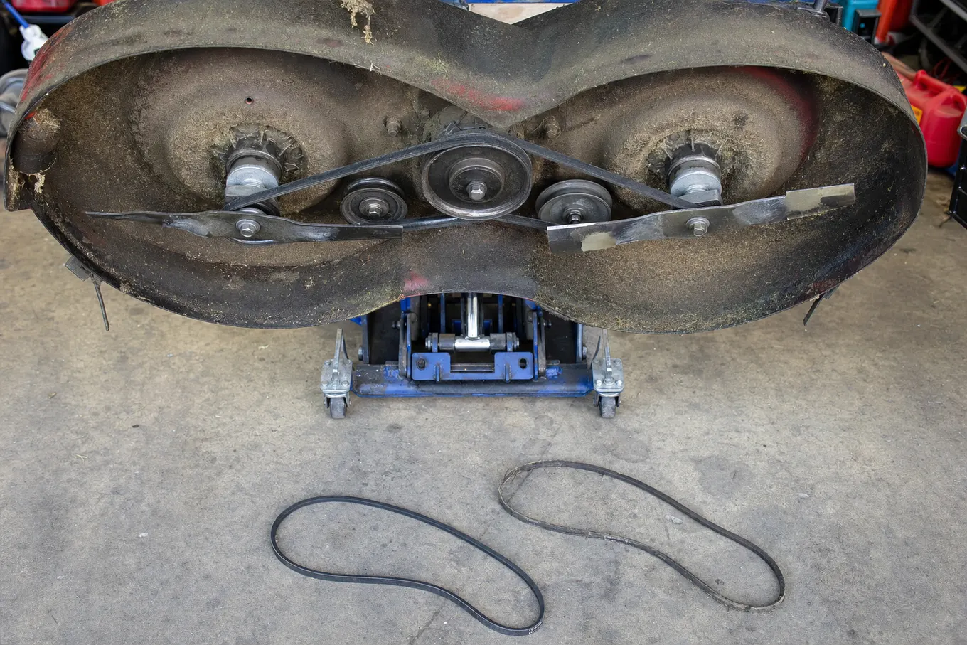 Mower deck with new belt routed around pulleys and spindles