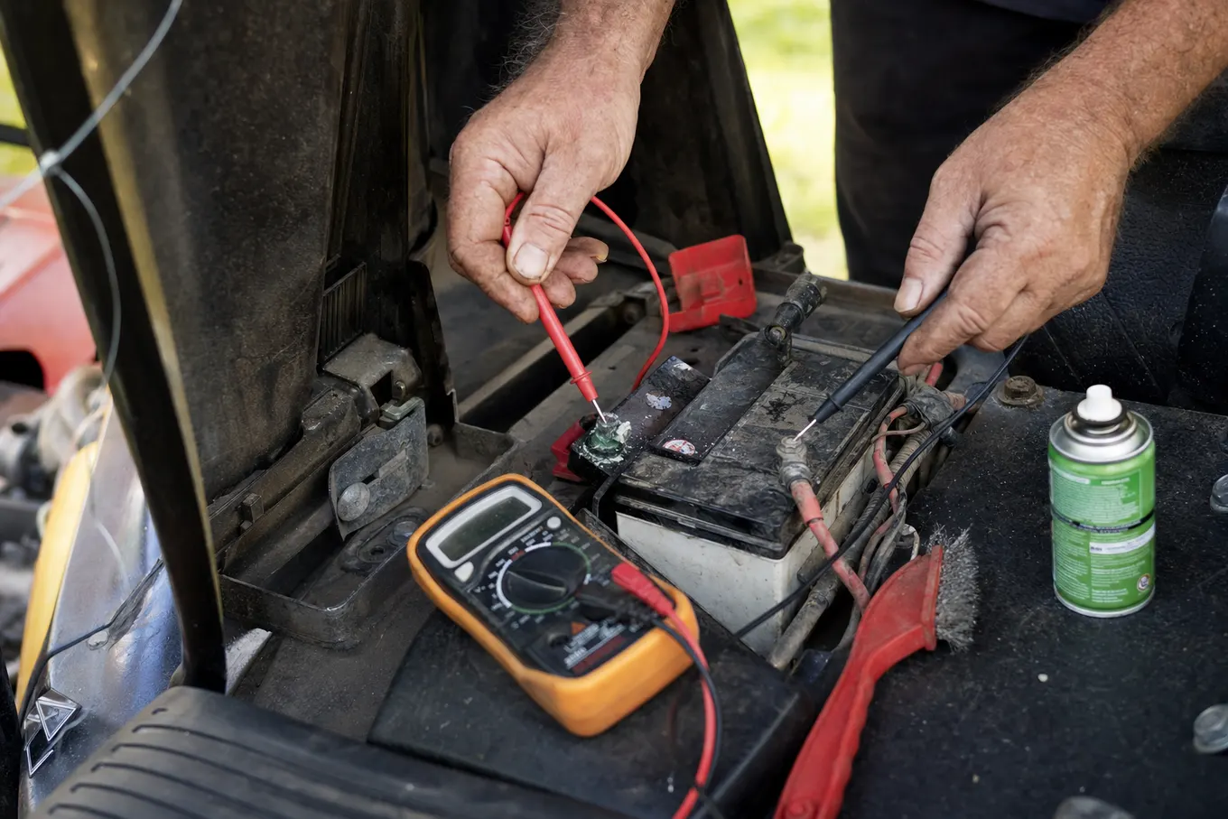 Multimeter testing a riding mower battery and starter circuit