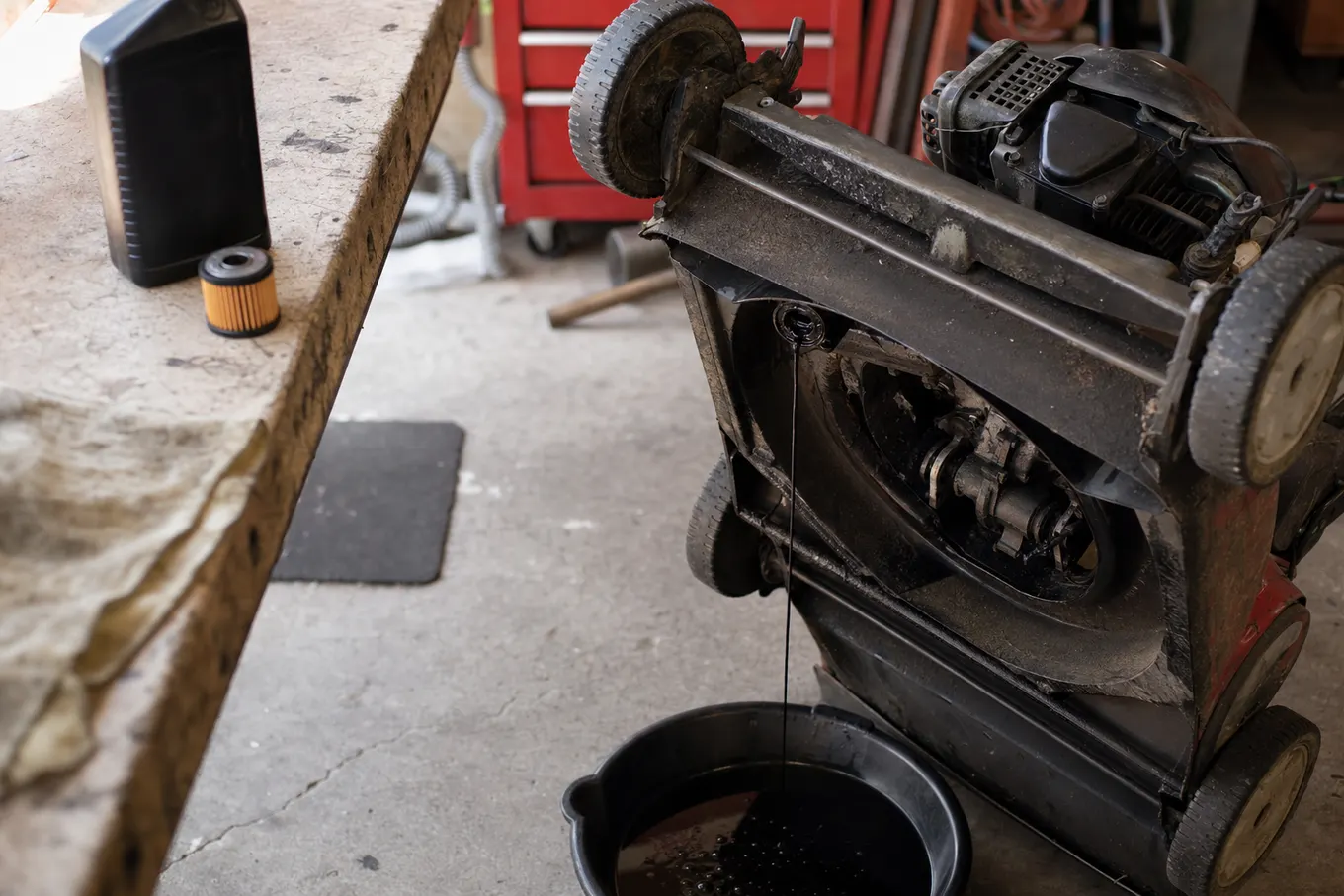 Oil draining from a lawn mower during scheduled maintenance at a Port Charlotte shop